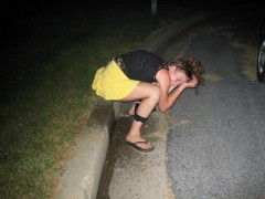 Pretty brunette peeing and posing in high green grass