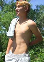Pretty gay twink gets naked in the middle of a meadow and plays with his sweet uncut cock
