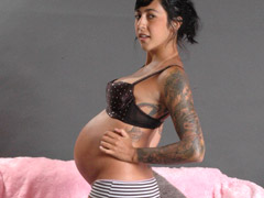 Preggo girl with a huge belly takes off all of her clothes.